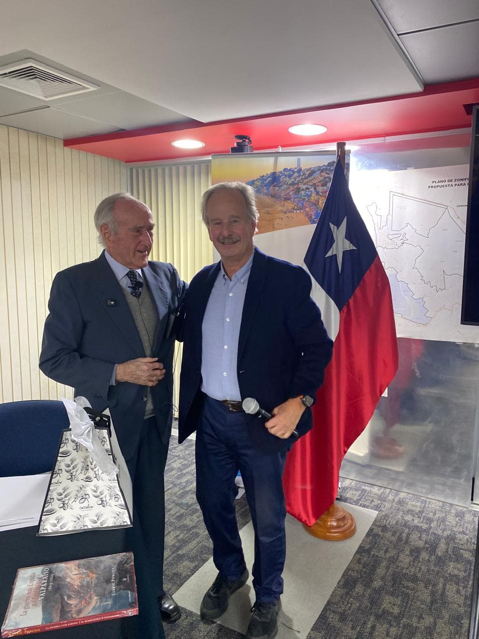 Cedric Purcell de la Vega junto a un socio de Arrebol al término de la conferencia, con su libro sobre la mesa.